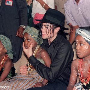 Michael Jackson sits with Ivory Coast children during a visit in 1992.