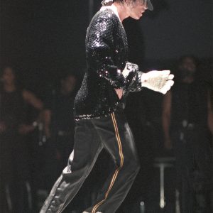 Michael Jackson moonwalks on stage during a concert tour.